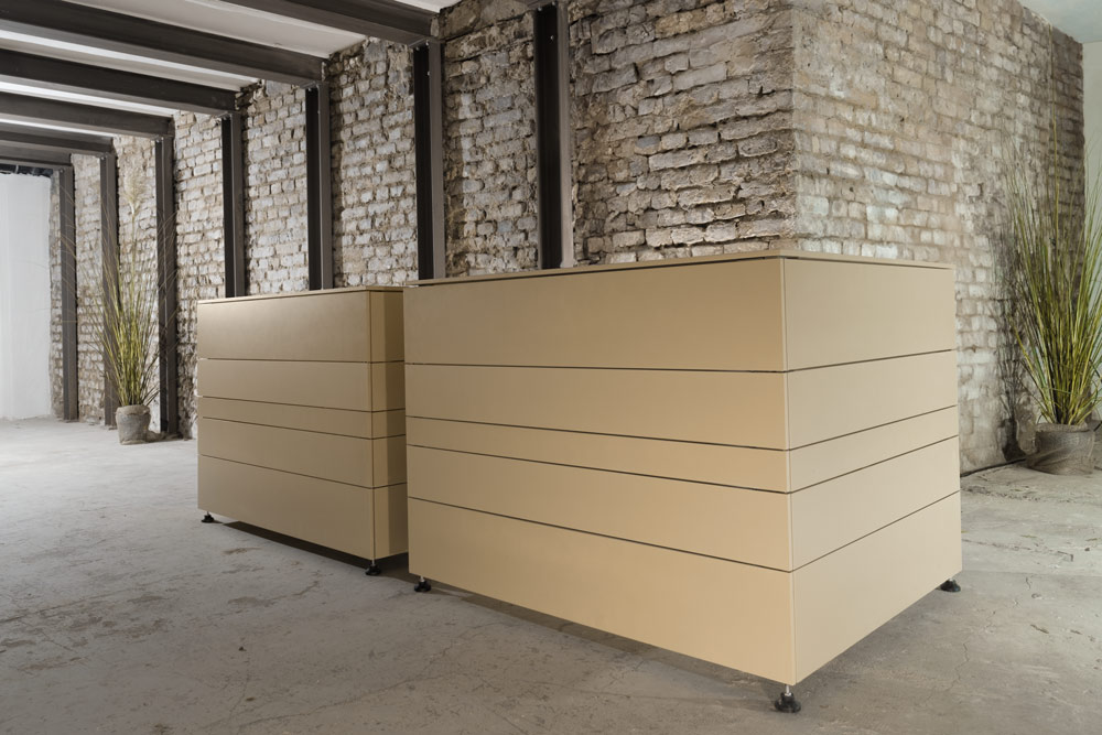 Moderne mobile Bar aus beigefarbenem Material in industrieller Loft-Atmosphäre mit Backsteinwänden und Stahlträgern