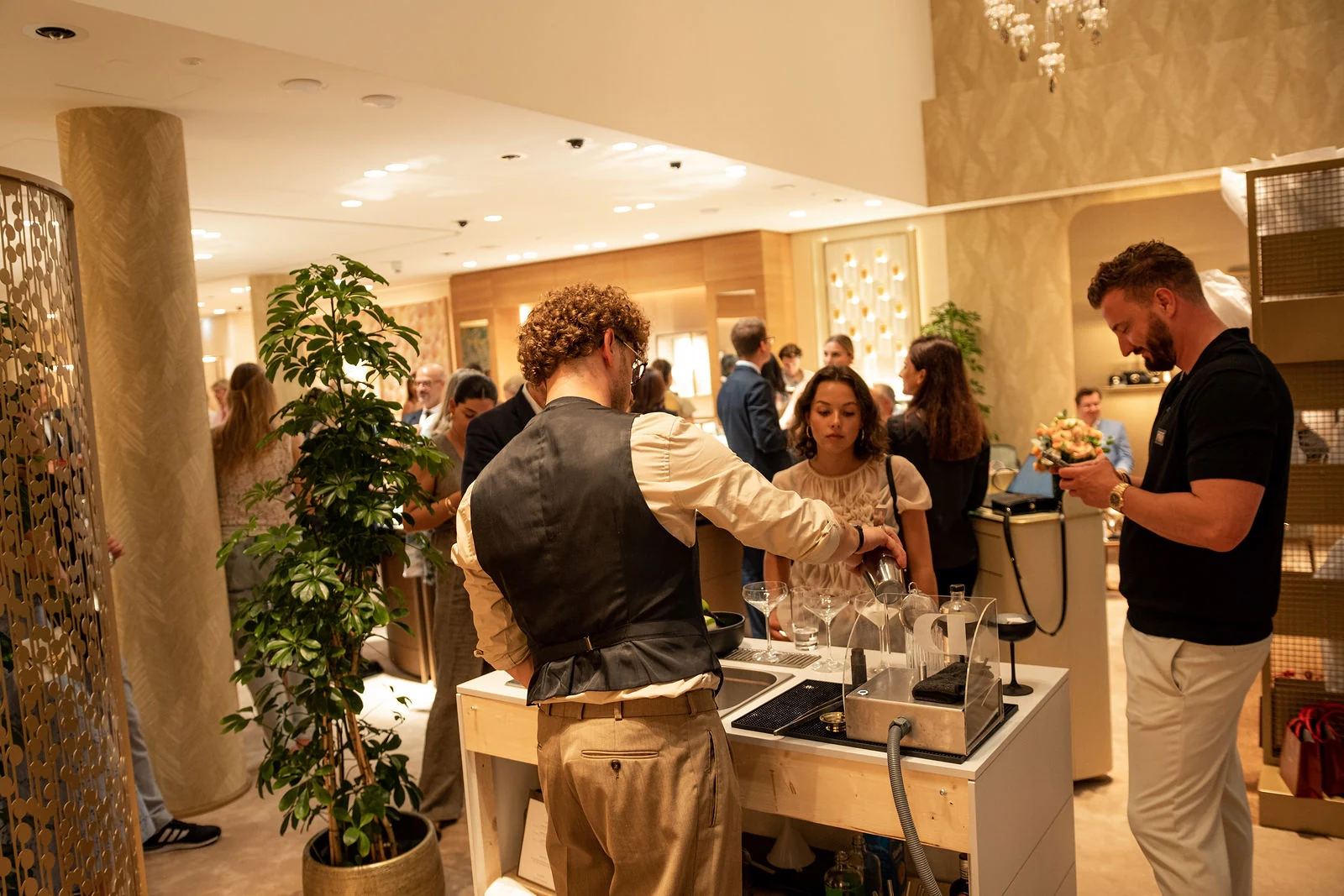 Gäste rings um unsere mobile Cocktailbar in Wien, hinter der ein Barkeeper Drinks zubereitet