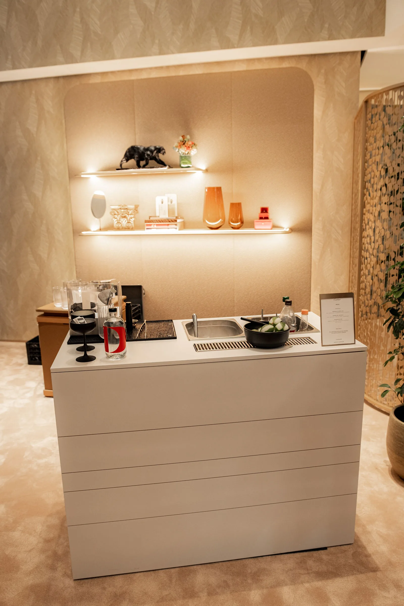 Frontalansicht auf unsere mobile Cocktailbar in Wien, aufgeräumt vor einem beleuchteten Regal