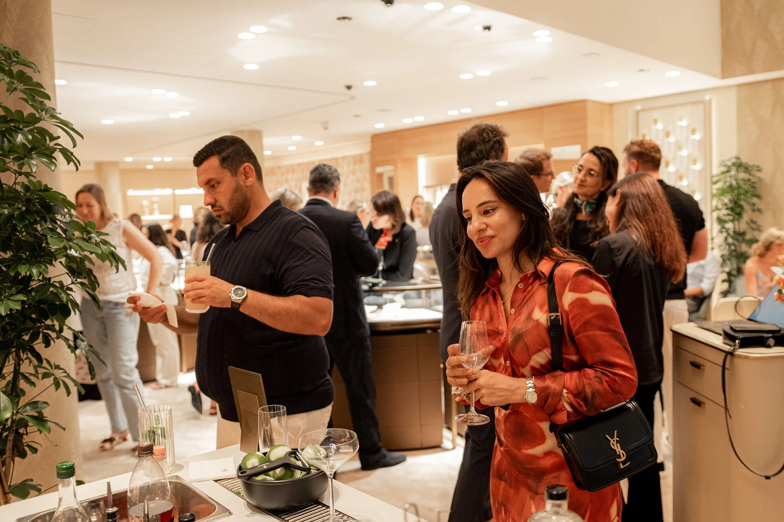 Mit Drinks in den Händen stehen Gäste an der mobilen Bartheke beim Boutique-Event in Wien