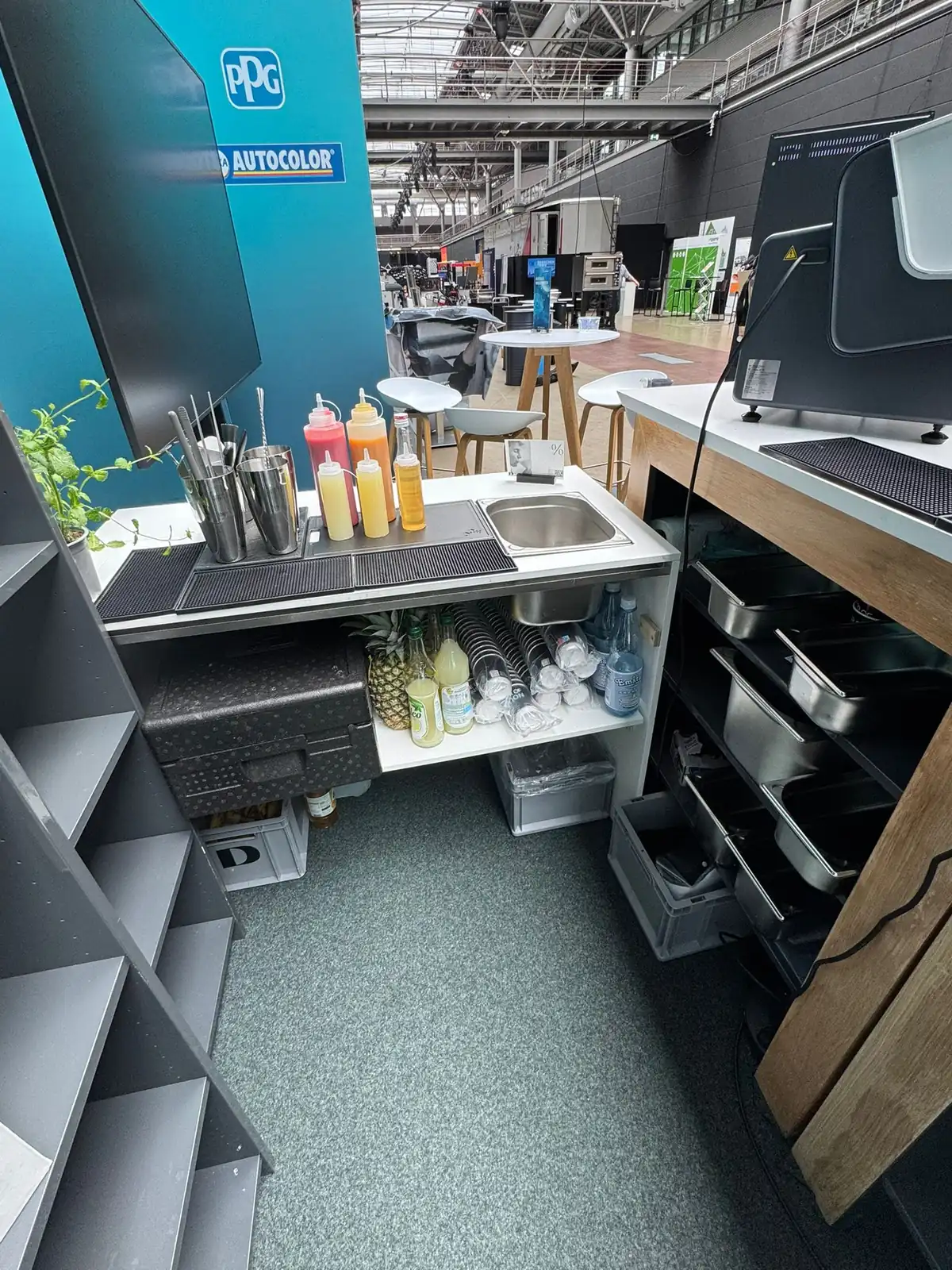 Arbeitsbereich der mobilen Bar mit Sirupen, Obst und Bechern am PPG-Stand